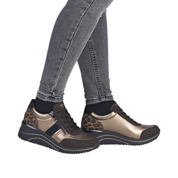 Tennis femme Matière stretch Talon compensé Lacet + fermeture éclair REMONTE coloris marron bronze imprimé léopard. Vue de côté de deux chaussures portées.