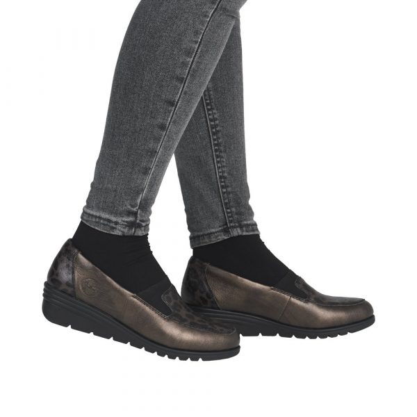 Mocassin femme Talon compensé Côtés élastiqués Dessus cuir Doublure textile RIEKER L5351-90 Coloris marron bronze. Vue de profil de deux chaussures portées par une dame.