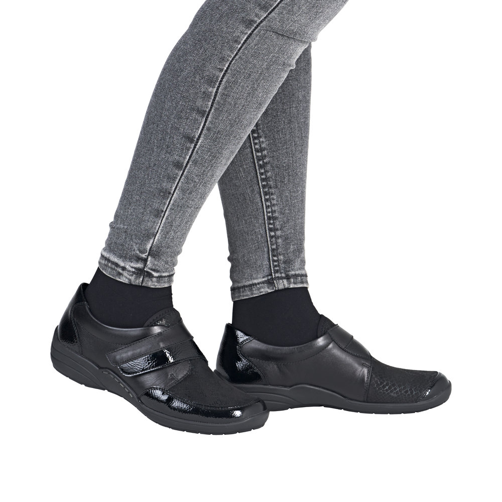 Chaussure basse confort Légère femme Velcro Semelle compensée Souple Stretch REMONTE R7600 coloris noir multi/vernis noir. Vue de côté de deux chaussures portées.