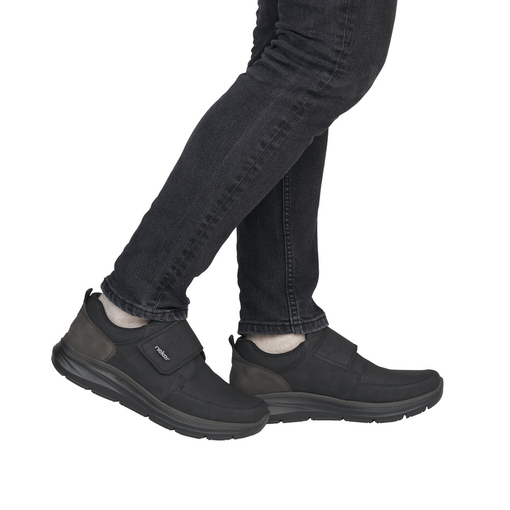 Chaussure basse homme Scratch Semelle souple Sneakers Simili cuir RIEKER B1854 Coloris noir. Vue de profil de deux tennis portées.